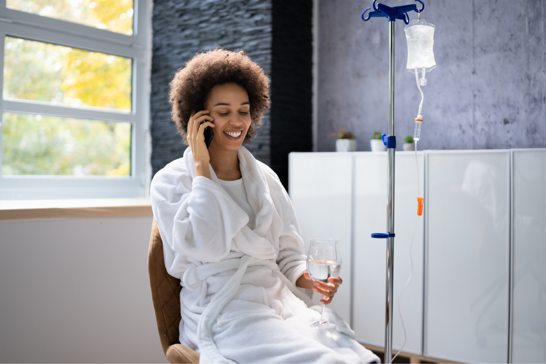 A mother wearing bathrobe and relaxing while attached to IV infusion drip