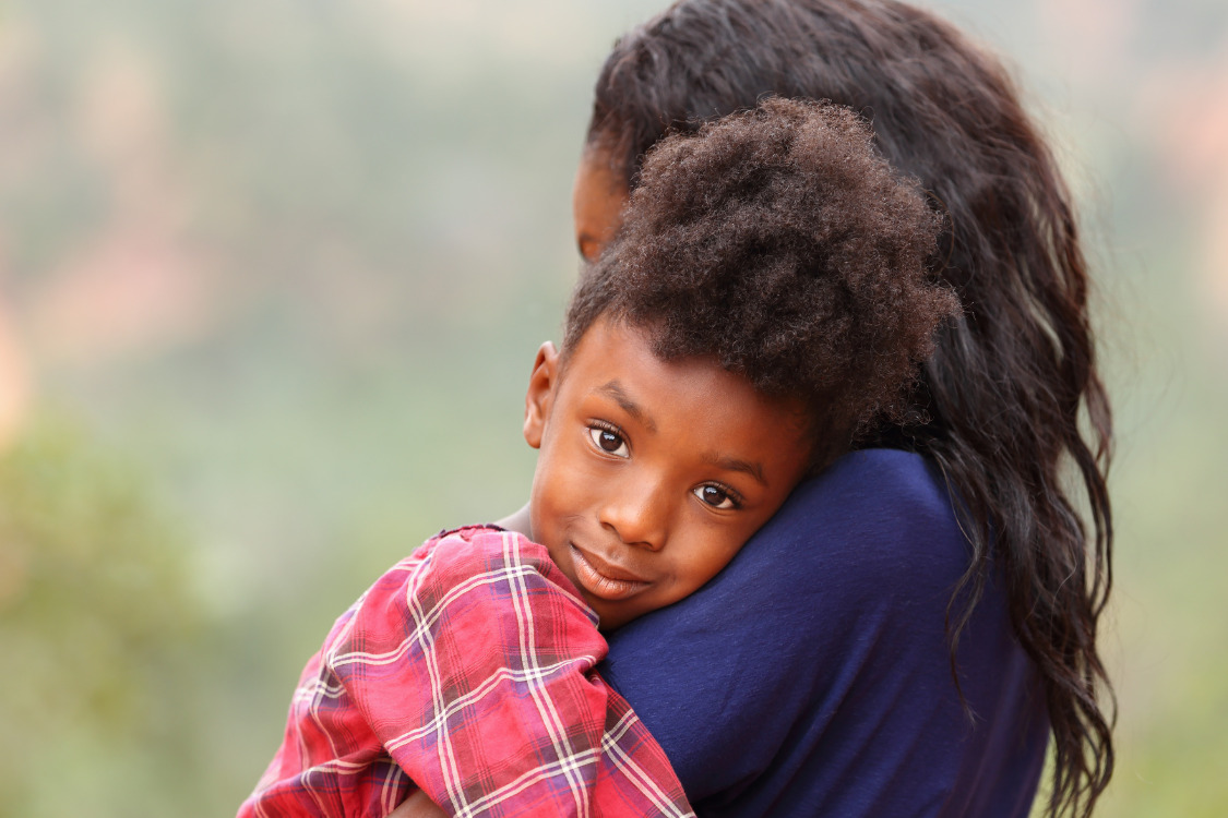 A mother hugging her daughter.