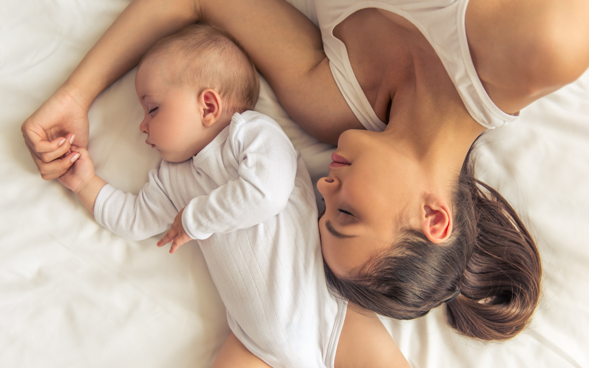 A mother sleeping with her baby in their Burtonsville, MD home.